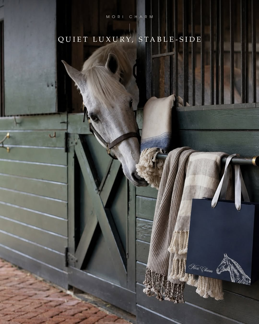 White horse with Mori Charm bags stable-side